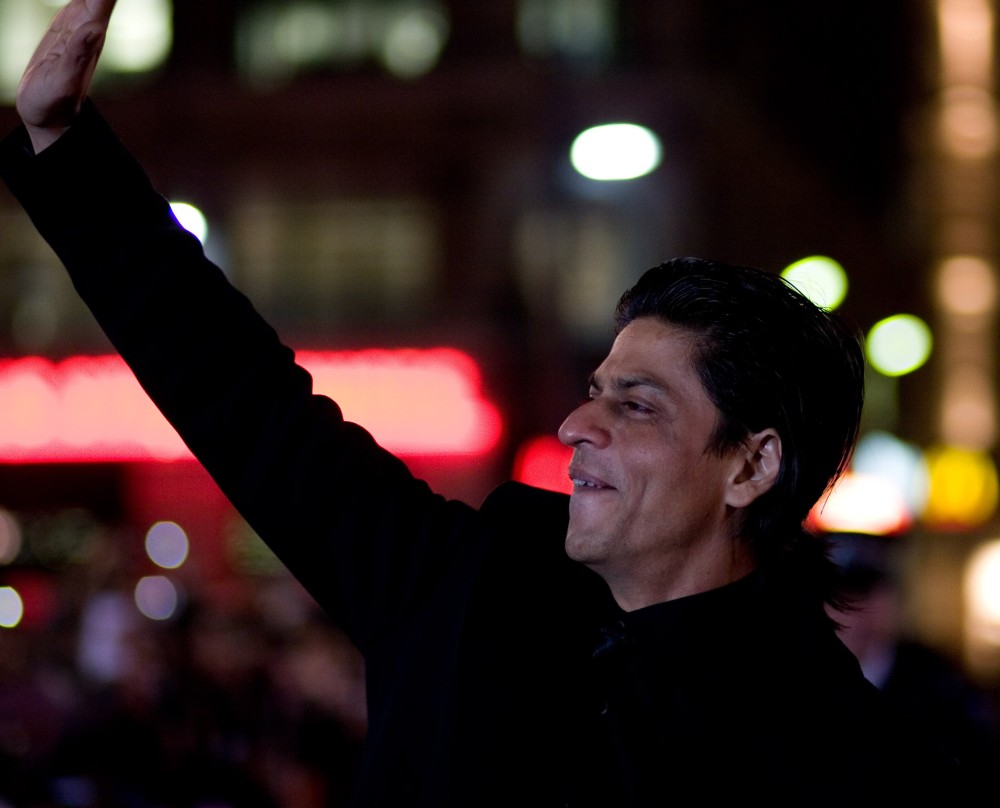 Shah Rukh Khan winkt Fans auf einer internationalen Bühne